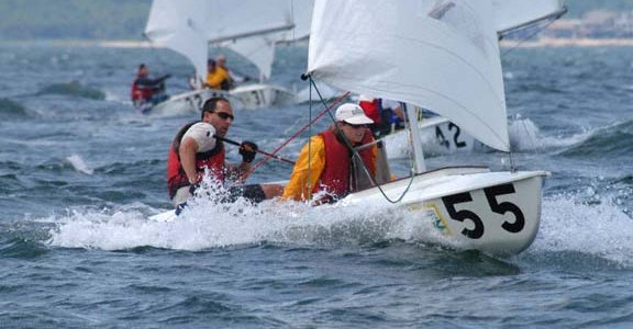 two people on a small sailboat in windy conditions